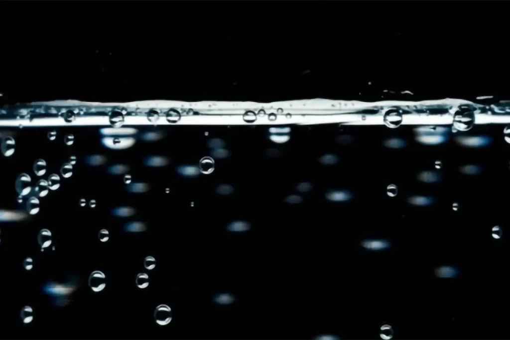 A black background with water droplets falling.